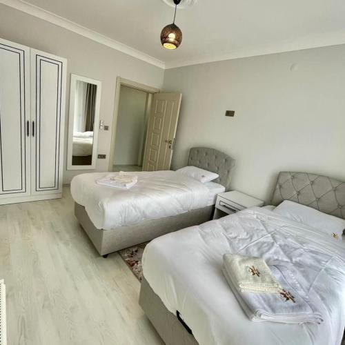 a hotel room with two beds and a couch at Shahin Golden Hotel الصقر الذهبي للشقق الفندقية in Bostancı