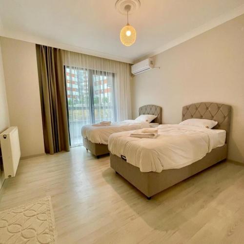 a bedroom with two beds and a window at Shahin Golden Hotel الصقر الذهبي للشقق الفندقية in Bostancı