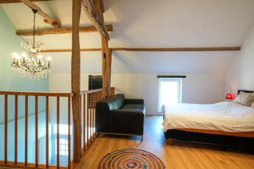 a bedroom with a bed and a couch and a chandelier at Fijn, recent volledig gerenoveerd appartement in Maastricht in Maastricht