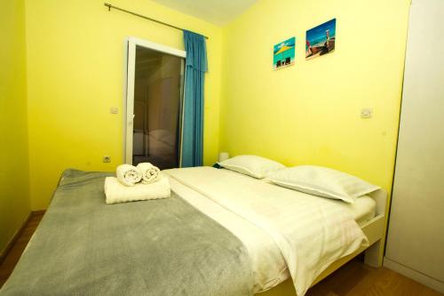 sypialnia z łóżkiem i ręcznikami w obiekcie Apartment Neno w mieście Sutomišćica