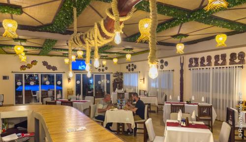 dos personas sentadas en una mesa en un restaurante en BIRA Hotel, en Antsirabe