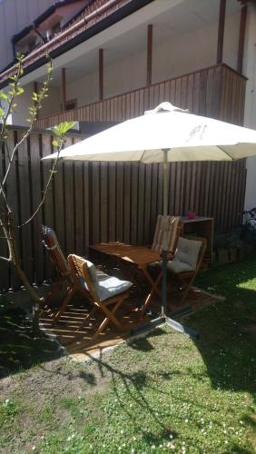 a wooden table and chairs under an umbrella at Apartment Slovan in Škofja Loka