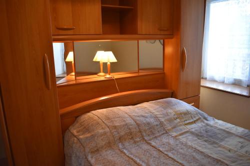 une chambre avec un lit, une lampe et une fenêtre dans l'établissement Le Pisé, à La Celle-sous-Gouzon