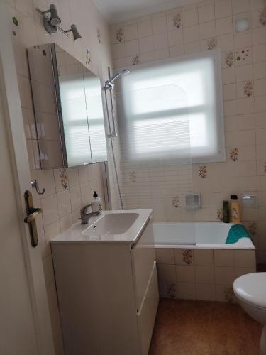a bathroom with a sink and a tub and a mirror at En el Parque de las Meanas. in Avilés