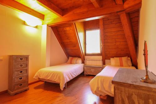 a bedroom with two beds in a log cabin at El Betato in Tramacastilla de Tena