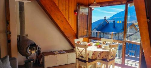 una sala da pranzo con un tavolo e una grande finestra di El Betato a Tramacastilla de Tena