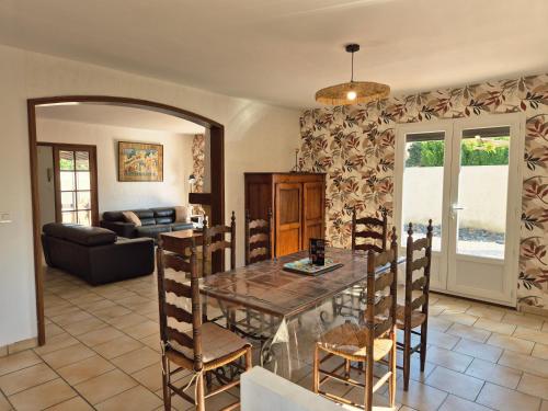 une salle à manger avec une table et un canapé dans l'établissement Maison Des myrtes, à Narbonne
