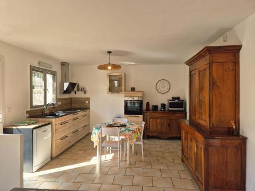 une cuisine avec une table et des chaises dans l'établissement Maison Des myrtes, à Narbonne