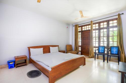 a bedroom with a bed with white sheets and a window at Exotic Villa Homestay in Guwahati