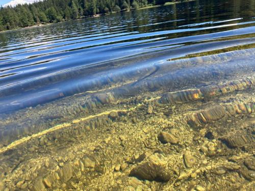 a body of water with rocks in the water at Haus Kampl - Appartement Ödensee in Obersdorf