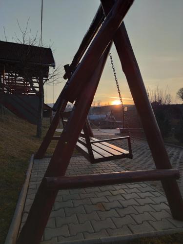 a swing set with the sunset in the background at Casa Daya in Topliţa