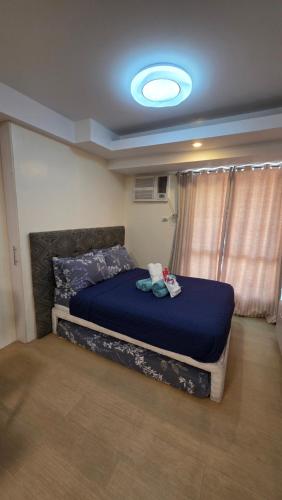 宿务Cozy Studio Apartment at Cebu IT Park的卧室里有一张床，床铺是蓝色的