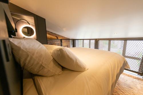 a bedroom with a large bed with a balcony at La grange moderne aux portes de Lyon in Vourles