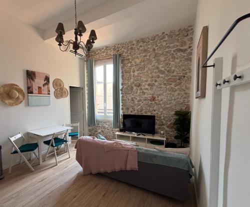 un salon avec un mur en pierre dans l'établissement Lovely Old Town Flat - Les Remparts, à Antibes