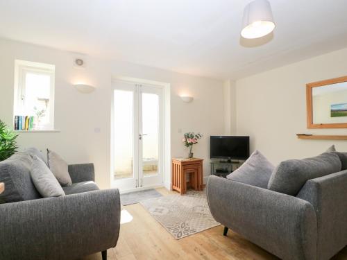 a living room with two couches and a tv at 9 Malthouse Court in Watchet