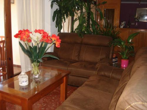 a living room with a couch and a table with flowers at Hotel Goya in Almuñécar