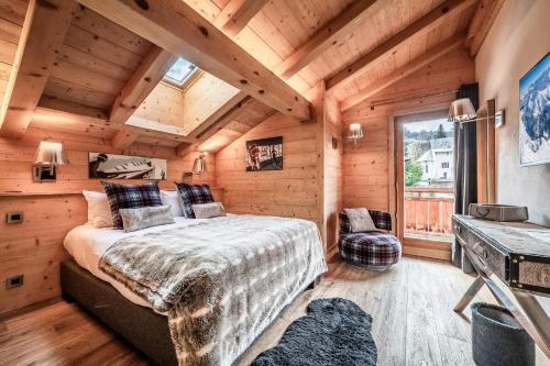 une chambre avec un lit dans une cabane en bois dans l'établissement Apartment Solstice Les Gets - by EMERALD STAY, aux Gets