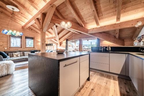 Il dispose d'une cuisine ouverte avec des plafonds en bois et du parquet. dans l'établissement Apartment Solstice Les Gets - by EMERALD STAY, aux Gets
