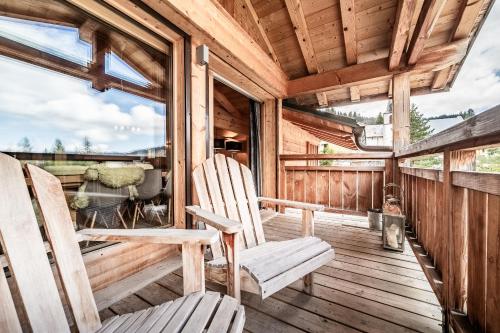 2 fauteuils à bascule sur une terrasse couverte d'une cabine dans l'établissement Apartment Solstice Les Gets - by EMERALD STAY, aux Gets