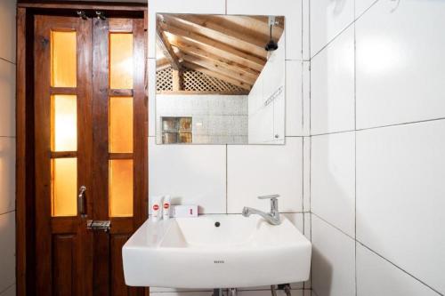 a white bathroom with a sink and a mirror at Hotel O Putroyono Homestay in Mendut