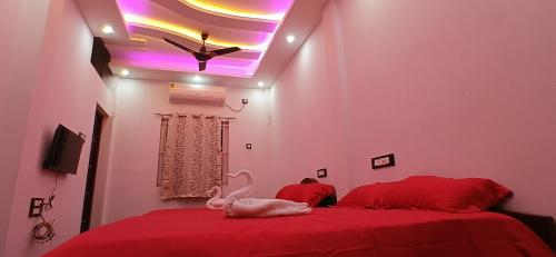 a bedroom with a red bed with a white swan on it at KK Dream Garden in Kāraikkudi