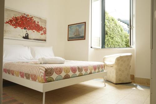 a bedroom with a bed and a chair and a window at Restart Accommodations Nerone in Anzio