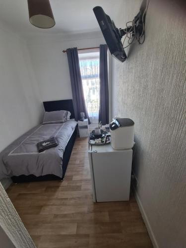 a small bedroom with a bed and a window at Tredegar Arms Budget Guesthouse For Walkers/Cyclists/Contractors/Traveler in Merthyr Tydfil