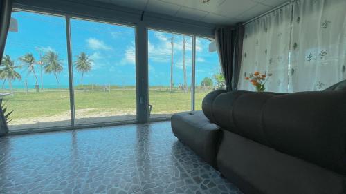 a living room with a couch and a view of the ocean at Earnhomestay sichon in Ban Plai Thon