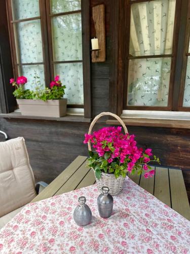 a table with a basket of pink flowers on it at Chalet-Simmi in Wimmis