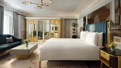 a bedroom with a large white bed and a couch at Mandarin Oriental Hyde Park, London in London
