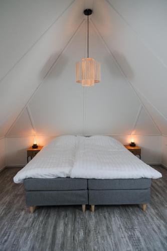 a bed in a room with a roof at Landhuisje in Hoogersmilde