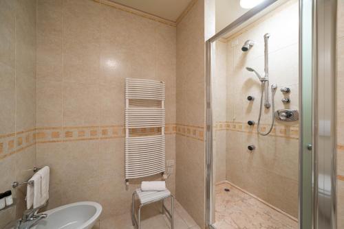 a bathroom with a shower and a toilet and a sink at Phi Hotel Astoria in Susegana