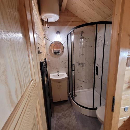 a bathroom with a shower and a toilet and a sink at Domki nad morzem Jula in Wrzosowo