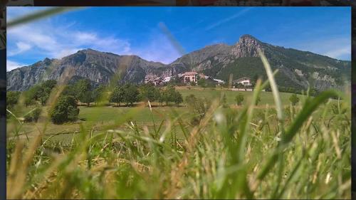 a view of a mountain from a field of grass at Gîte-Auberge l'écureuil in Châteauneuf-dʼEntraunes