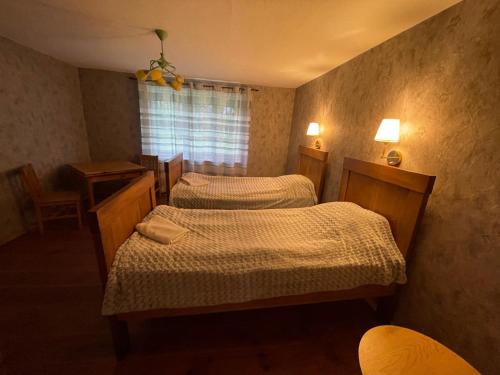 a bedroom with two beds and a window at Lauku viesu māja Bajāri in Rucava