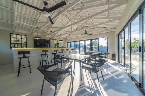 a bar with tables and chairs in a room with windows at Room 3 - LEO Sky Guest House in Simondium