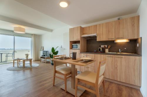 a kitchen and dining room with a table and chairs at Résidence de Brest Lambézellec in Brest
