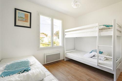 a bedroom with two bunk beds and a window at Grande maison entre plage et foret in Saint-Trojan-les-Bains