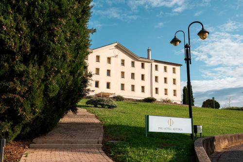 a large white building with a sign in front of it at Phi Hotel Astoria in Susegana