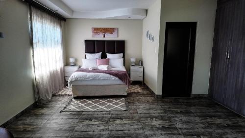 a bedroom with a large bed and a large window at Ondjo Yetu in Benoni