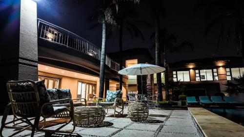 a patio with chairs and an umbrella next to a pool at Ondjo Yetu in Benoni