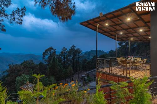 a patio with a view of the mountains at night at StayVista at tatvam-Mountain views & EV Station in Lansdowne