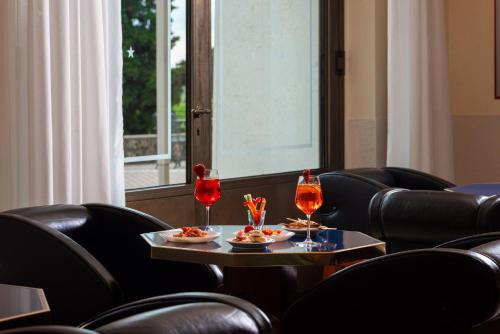a room with chairs and a table with drinks and snacks at Phi Hotel Astoria in Susegana