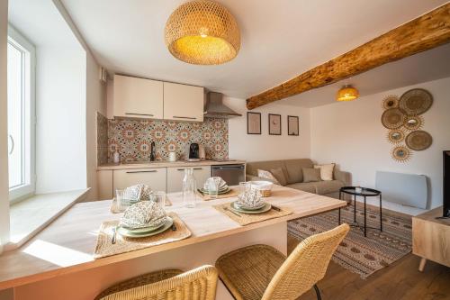 une cuisine et un salon avec une table et des chaises dans l'établissement La Bastide - Terrasse - Jacuzzi, à Carcassonne