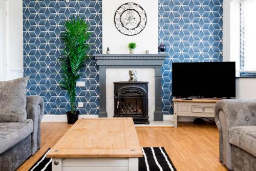 a living room with a fireplace and a tv at Modern and Spacious 4 Bedroom Home in Ipswich in Ipswich