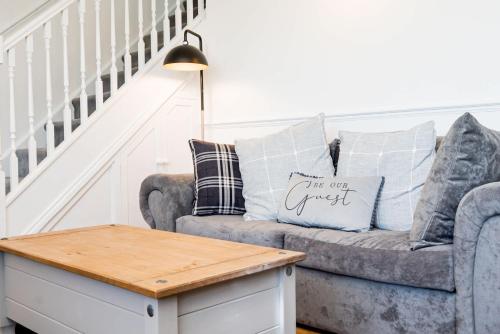 a living room with a grey couch with pillows at Modern and Spacious 4 Bedroom Home in Ipswich in Ipswich