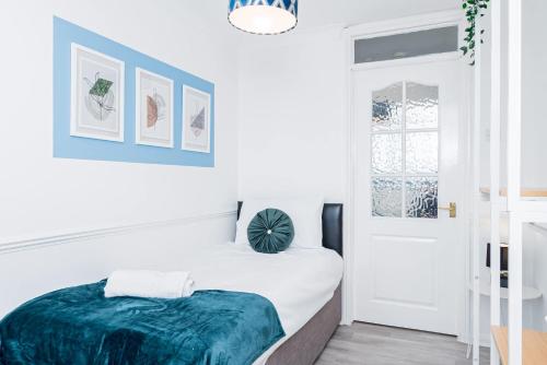a white bedroom with a bed with a blue blanket at Modern and Spacious 4 Bedroom Home in Ipswich in Ipswich