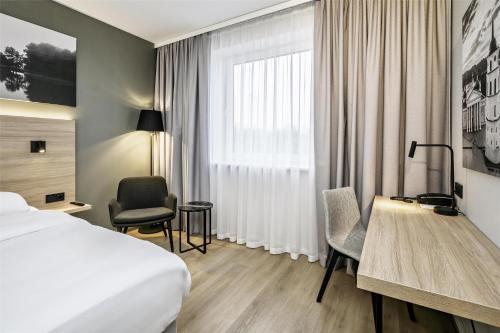 a hotel room with a bed and a desk at Park Inn by Radisson Vilnius Airport Hotel & Conference Centre in Vilnius