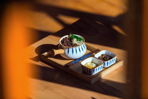 a table topped with a bowl of food and chopsticks at Lijiang half yard hotel in Lijiang
