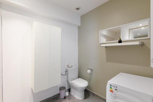 La salle de bains est pourvue de toilettes blanches et d'un réfrigérateur blanc. dans l'établissement Serenity apprt, à Théoule-sur-Mer